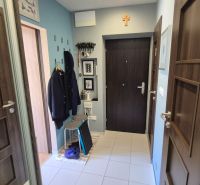 Entrance hall of a 2-room apartment with coat hooks, tiles, and wall decorations.
