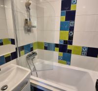 Colorful tiles in the bathroom with a bathtub in a 2-room apartment.