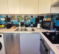 A kitchen in a 2-room apartment with tiles in a blue-black color combination.