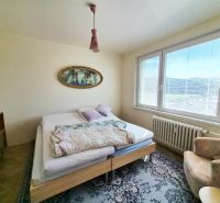 A bedroom with a bed, a chair, and a decorative painting in a 3-room apartment.