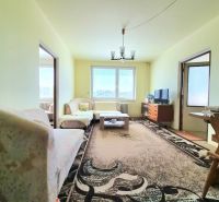 Living room in a 3-room apartment with sofas and carpets on a floor with a wooden decor.