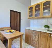 A kitchen in a 2-room apartment with a wooden decor and a kitchenette.