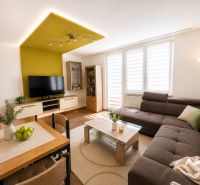 Spacious living room in a 3-room apartment with a corner sofa and a television.