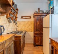 A kitchen in a 4-room apartment with historical furniture and a wooden decor floor.