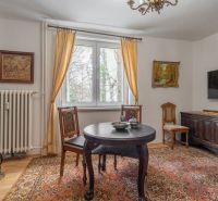 Interior of a 4-room apartment with wooden decor, antique furniture, and decorative carpets.