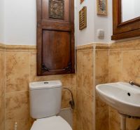 WC with wooden doors and a mirror, ceramic tiles, sink in a 4-room apartment.