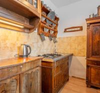 A kitchen with classic wooden furniture and a floor with a wooden decor in a 4-room apartment.