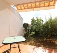 Terrace of a family house in Vodice with a table, chair, and a view of the garden.