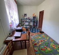Children's room with a road-shaped carpet, a desk, and a shelving unit.