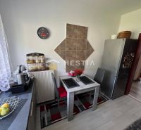 A kitchen with a dining table and a wooden decor floor in a 3-room apartment.