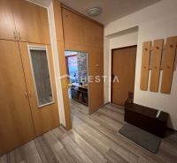 The hallway in a 3-room apartment with wooden decor and built-in wardrobes.