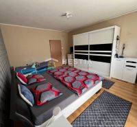 Bedroom in a 3-room apartment with a large wardrobe and a floor with a wooden decor.