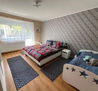 Bedroom with a double bed, a child's bed, and a wooden decor floor in a three-room apartment.