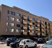 Apartment building on Sadova Street in Senica with parked cars and balconies.