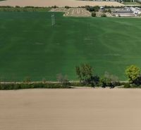 Recreational plots in Trhovište with expansive green and brown fields and trees.