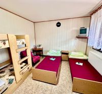 A room in a family house with a bunk bed and two single beds.