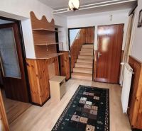 Interior with wooden paneling, floor with wooden decor, stairs, carpet, and furniture.