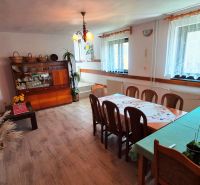 Interior of a family house with a dining table, sideboard, and wooden decor flooring.