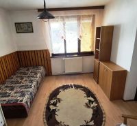 A room in a family house with a bed, shelves, and a floor with a wooden decor.