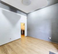 Empty interior with wood-patterned flooring and a transition to another room in the Gastro premises.