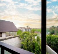 View from the villa in Bali with palm trees and green landscape.