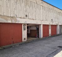 Garages on Hanulova Street in Bratislava – Dúbravka with red doors and a concrete surface.
