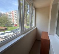 A studio apartment with a glazed loggia overlooking greenery and a parking lot in Bratislava-Petržalka.