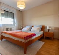 Bedroom with a double bed, nightstand, and wood-patterned flooring in a 4-room apartment.