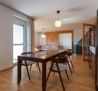 A stylish dining room with wood-patterned flooring and modern furniture in a 4-room apartment.