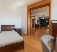 Bedroom with a bed and a dresser, connected to the kitchen, floor with a wooden decor.