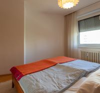 A bedroom in a 4-room apartment with a bed and a floor with a wooden decor.