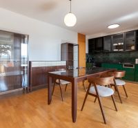 Dining area in a 4-room apartment with modern furniture and wooden decor flooring.
