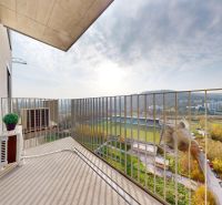The balcony in Bratislava-Dúbravka at Polianky offers a view of the surrounding greenery and the stadium.