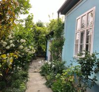 A family house on a street in Majcichov with a blue facade and a garden path.