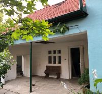 A family house in Majcichov on Majcichov Street with a garden, a bench, and a red roof.