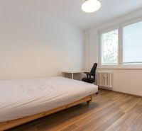 A bedroom with a single bed, a desk, and a wooden decor floor in a 3-room apartment.