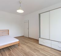 A bedroom in a 3-room apartment with a bed, cabinets, and a floor with a wooden decor.