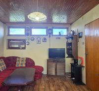 Living room in a cottage with a corner sofa and a wooden decor floor.