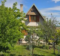 A cottage on Nové Vinohrady Street in Suchá nad Parnou surrounded by greenery and trees.