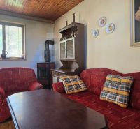 Living room in a cottage with a red sofa, wood-patterned floor, and a painting on the wall.