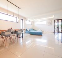 Living room with spacious tiles and a blue sofa in a family house.