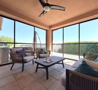 A glazed terrace with comfortable seating in a family house.