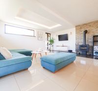 Living room in a family house with a fireplace, sofa, and light floors.