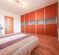 Bedroom in a family house with a built-in wardrobe and flooring with a wood decor.