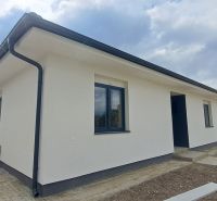 A family house in Selice with a white facade and black roofing elements.