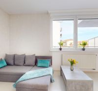 Living room in a studio apartment with a corner sofa and a coffee table.