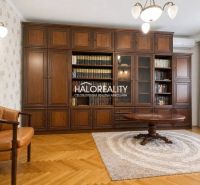 Living room in a 3-room apartment with a bookshelf, an armchair, and a wooden decor floor.
