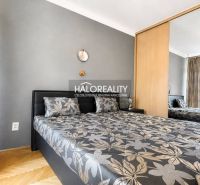 Bedroom with a double bed, mirrored wardrobe, and wooden decor flooring in a 3-room apartment.