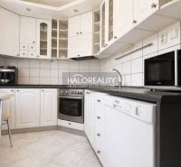 A kitchen in a 3-room apartment with a white kitchen unit and appliances.