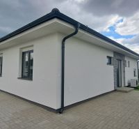 A family house in Topoľnica with a white facade and a paved terrace.